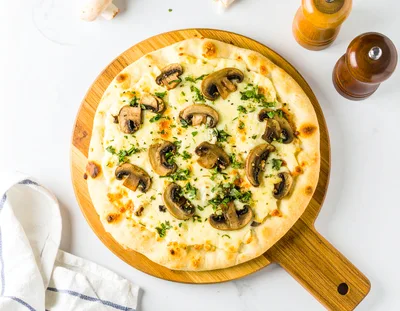 Fresh Mushroom Pizza On A Wooden Serving Board