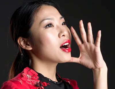 Asian Woman Calling Out With Hand Near Mouth