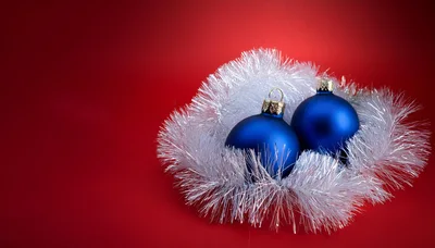 Two Blue Christmas Ornaments With Silver Tinsel