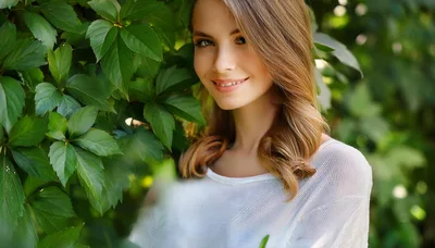 Young Woman Smiling Outdoors Near Green Foliage