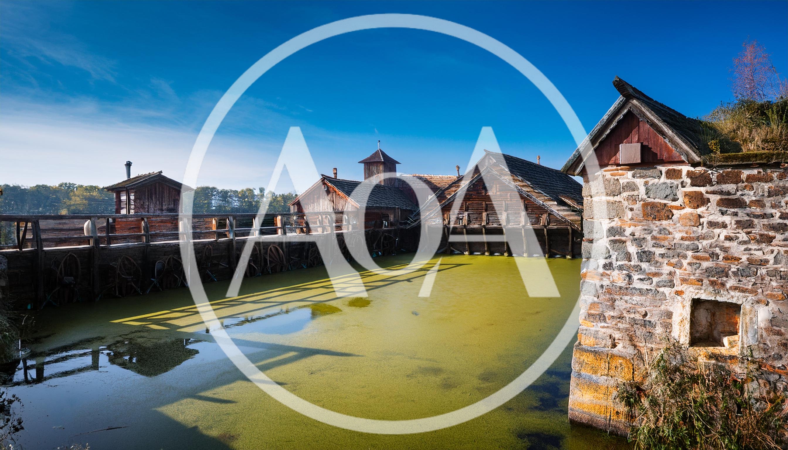 Historic Wooden Water Mill Structures On A Green Pond