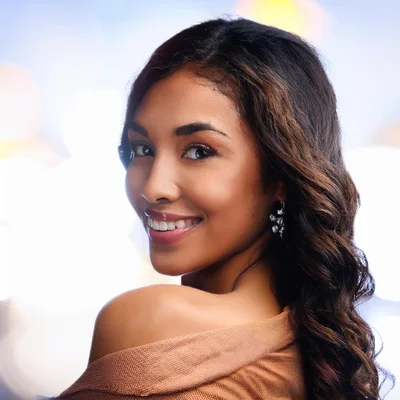 Portrait Of A Smiling Young Woman Looking Over Shoulder