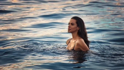 Beautiful Woman Swimming In Calm Ocean At Sunset