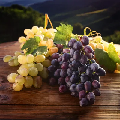 Fresh Green and Purple Grapes on Wooden Table