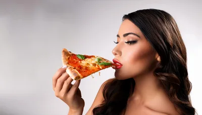 Beautiful Woman Eating A Slice Of Pizza