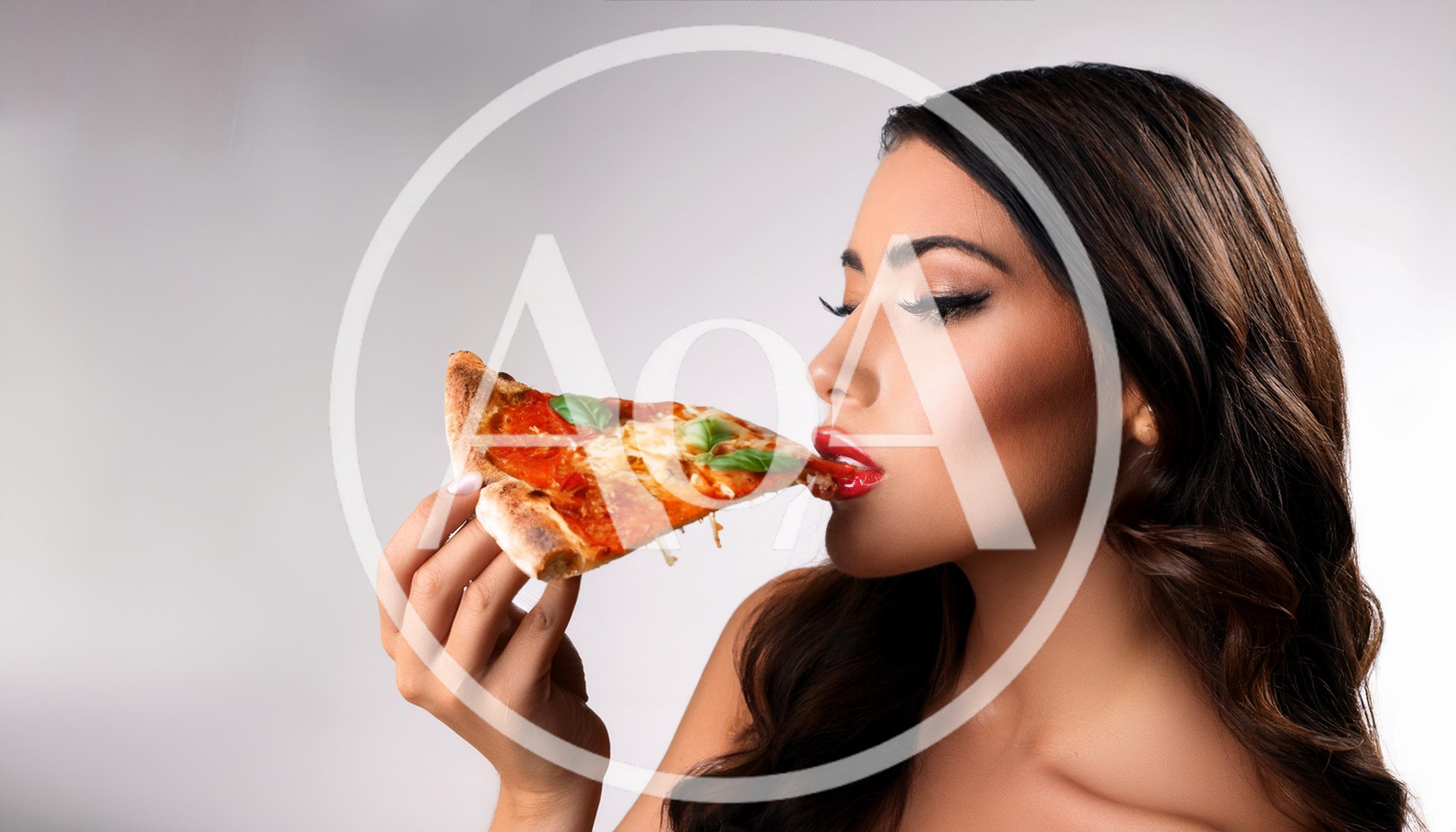 Beautiful Woman Eating A Slice Of Pizza