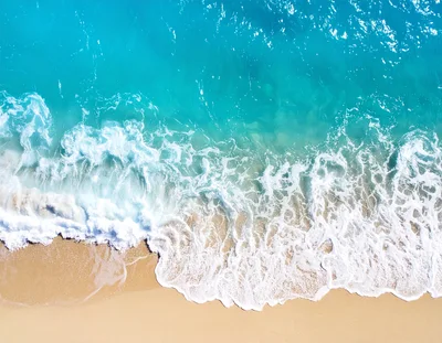 Aerial View Of Turquoise Ocean Waves Crashing On Beach