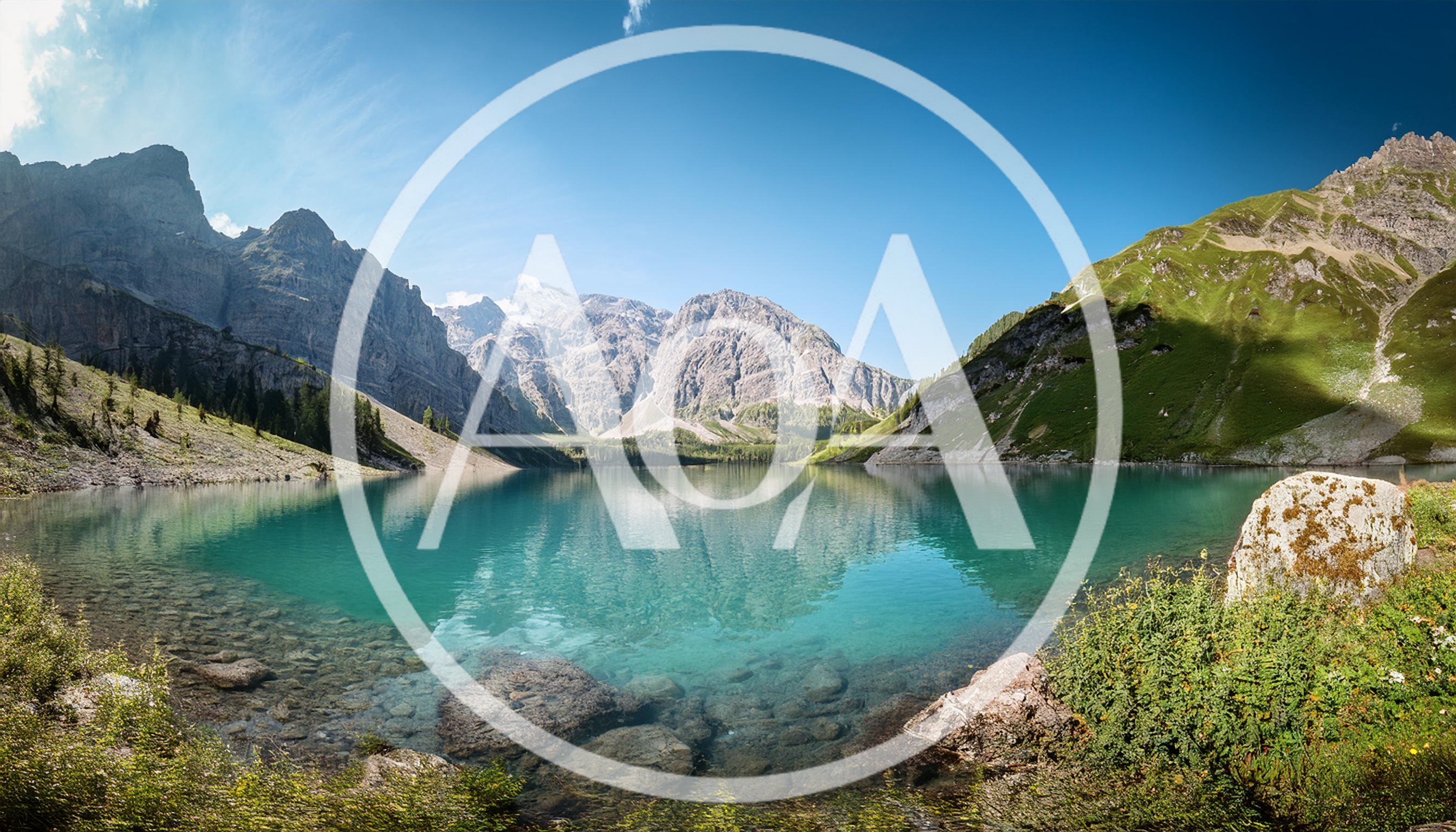 Panoramic View Of Turquoise Alpine Lake And Mountains