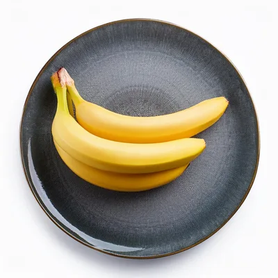 Three Fresh Yellow Bananas On A Textured Dark Plate