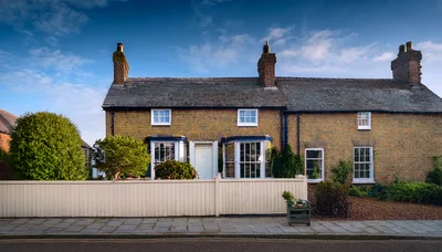 Traditional English Brick Cottage With White Picket Fence
