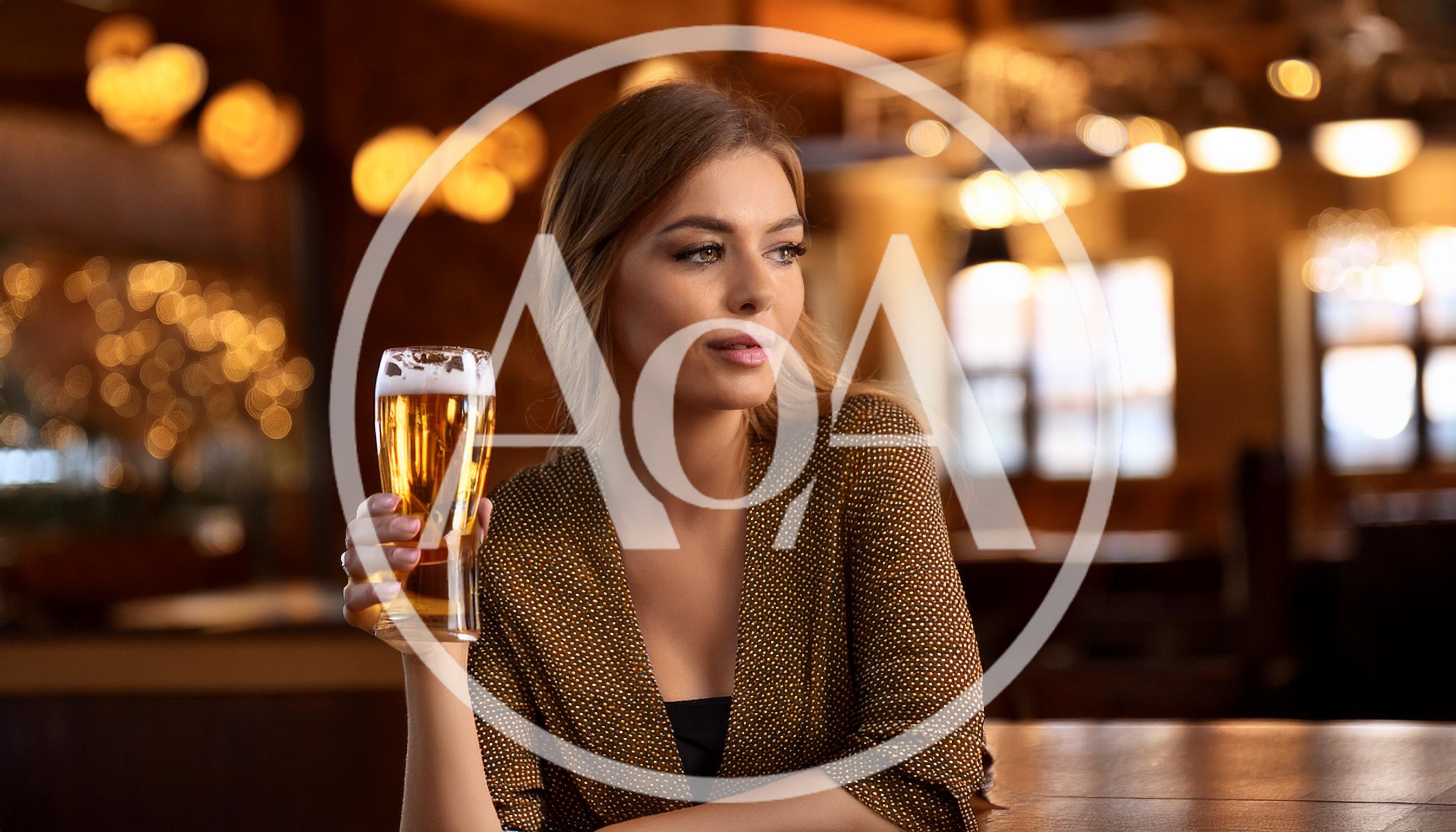 Young Woman Holding A Glass Of Beer In A Pub