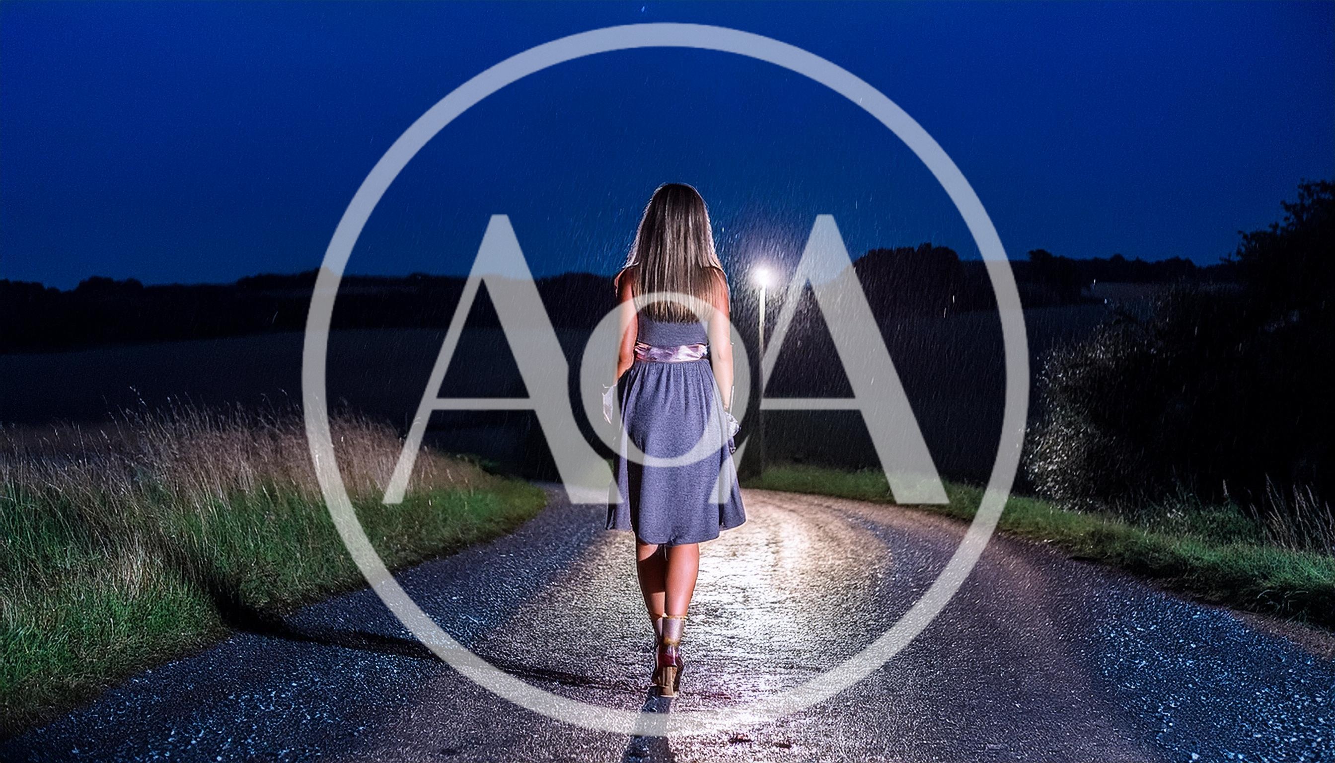 Woman Walking Alone On A Rainy Country Road At Night