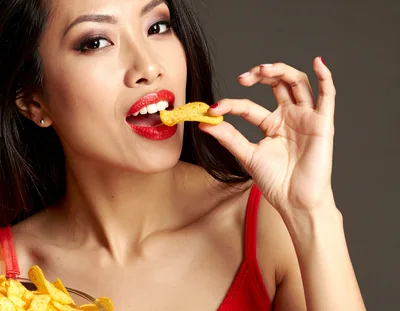 Young Woman Eating Potato Chips