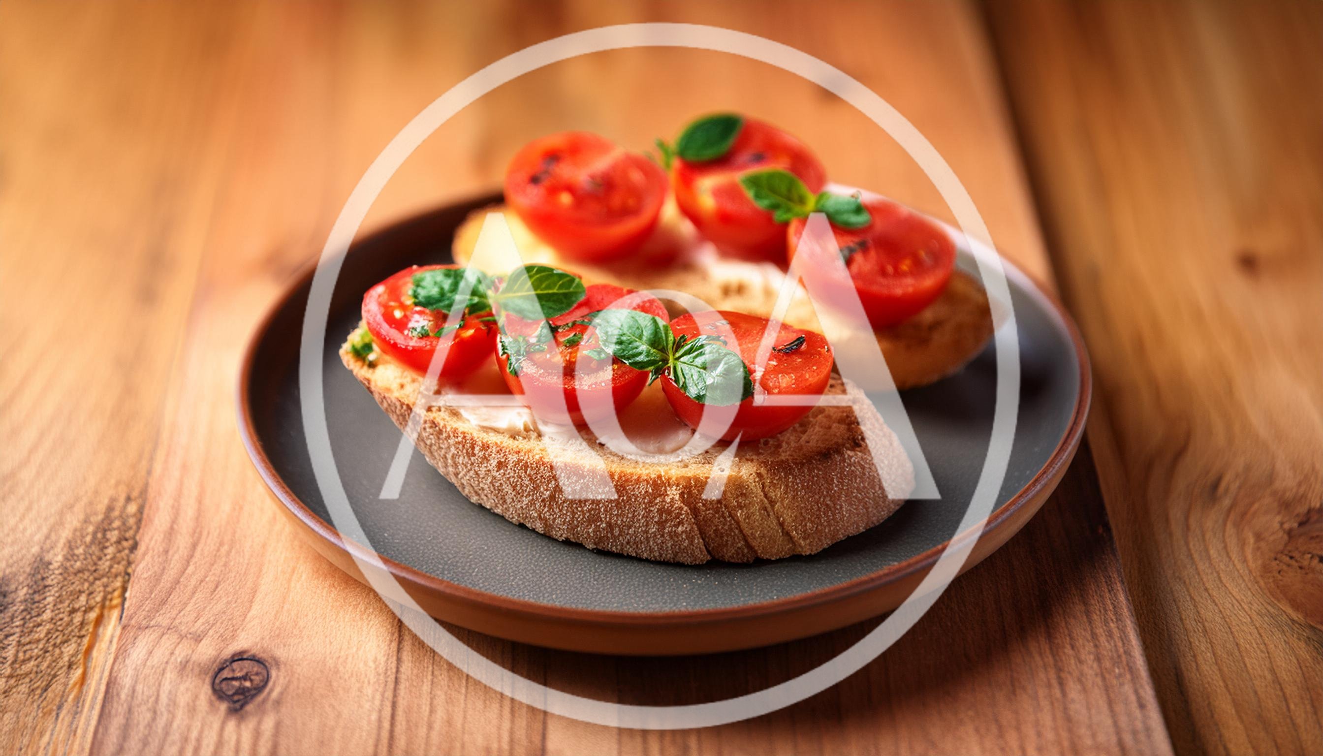 Two Pieces Of Tomato Bruschetta On A Plate