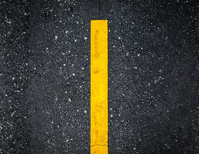 Yellow Painted Line On Wet Asphalt Road Surface