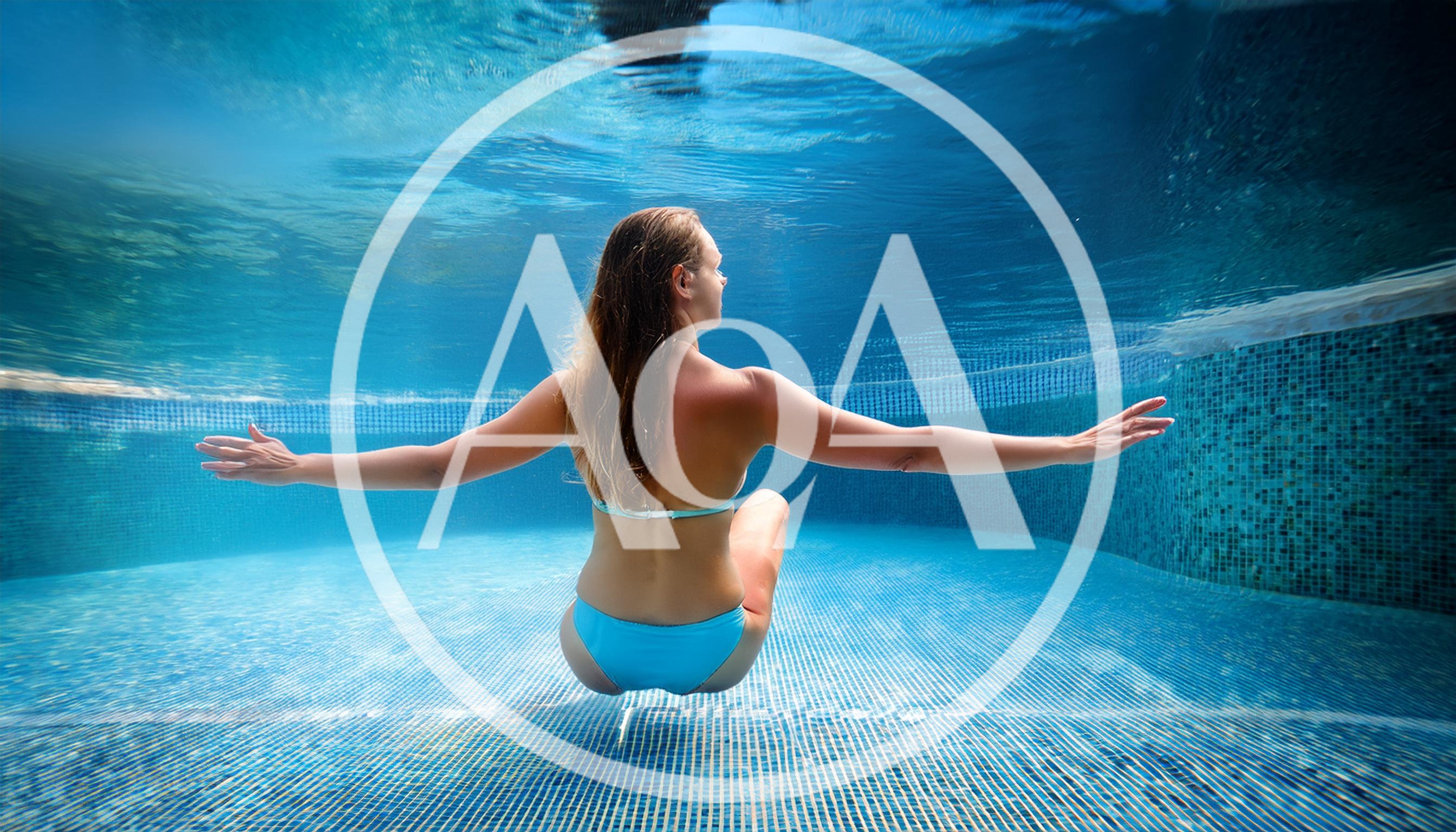 Woman Swimming Underwater In A Blue Tiled Pool