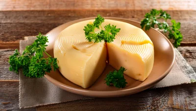 Wheel Of Sliced Cheese With Fresh Parsley Garnish