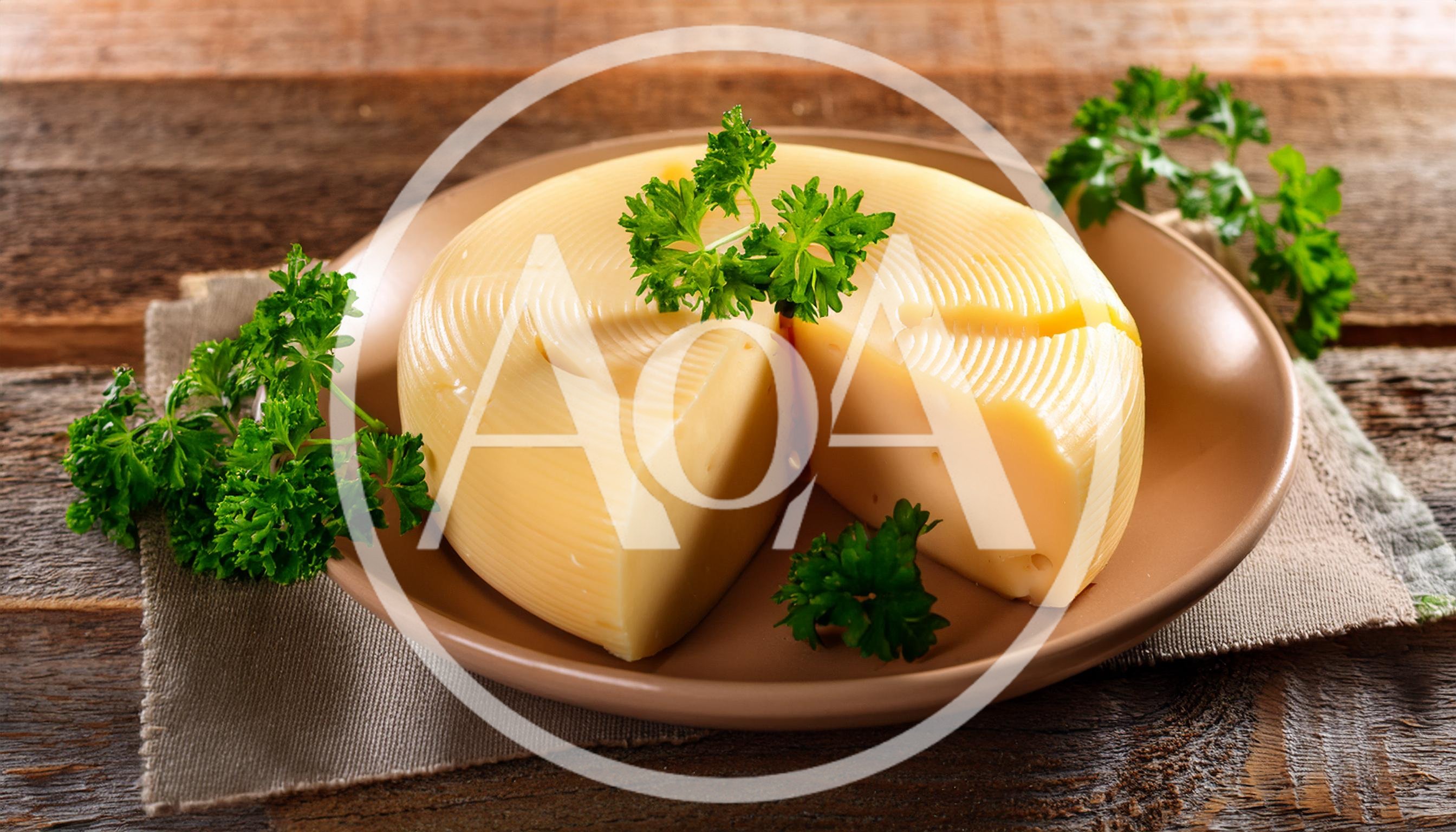 Wheel Of Sliced Cheese With Fresh Parsley Garnish