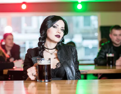Gothic Woman Drinking Dark Beer In A Pub