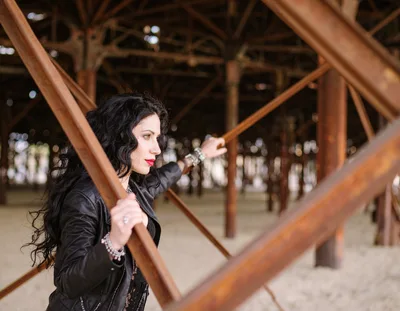 Woman With Dark Hair Posing Under A Pier
