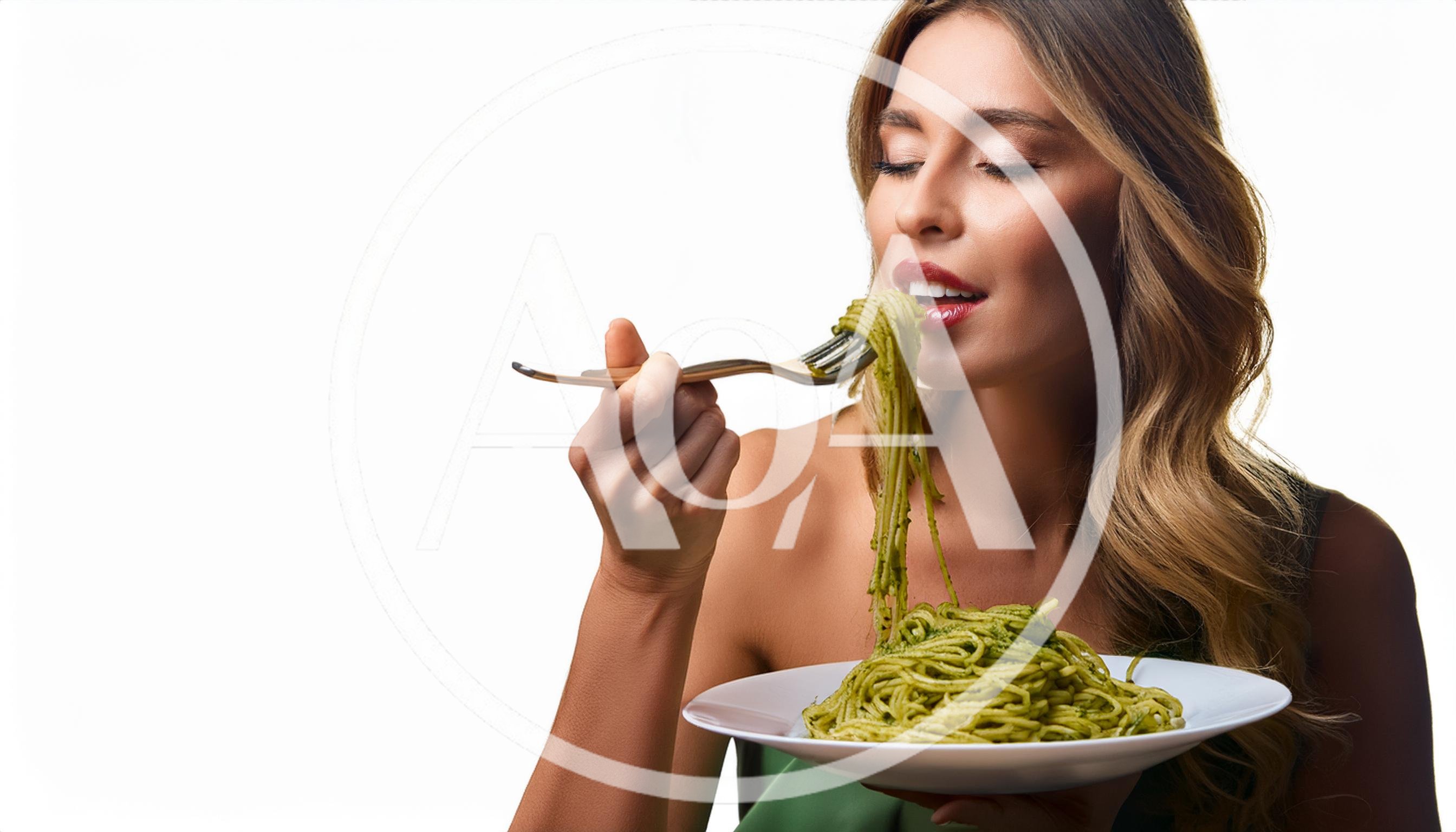 Woman Eating Pesto Pasta From A Fork