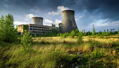 Abandoned Power Plant With Cooling Towers In Overgrown Field
