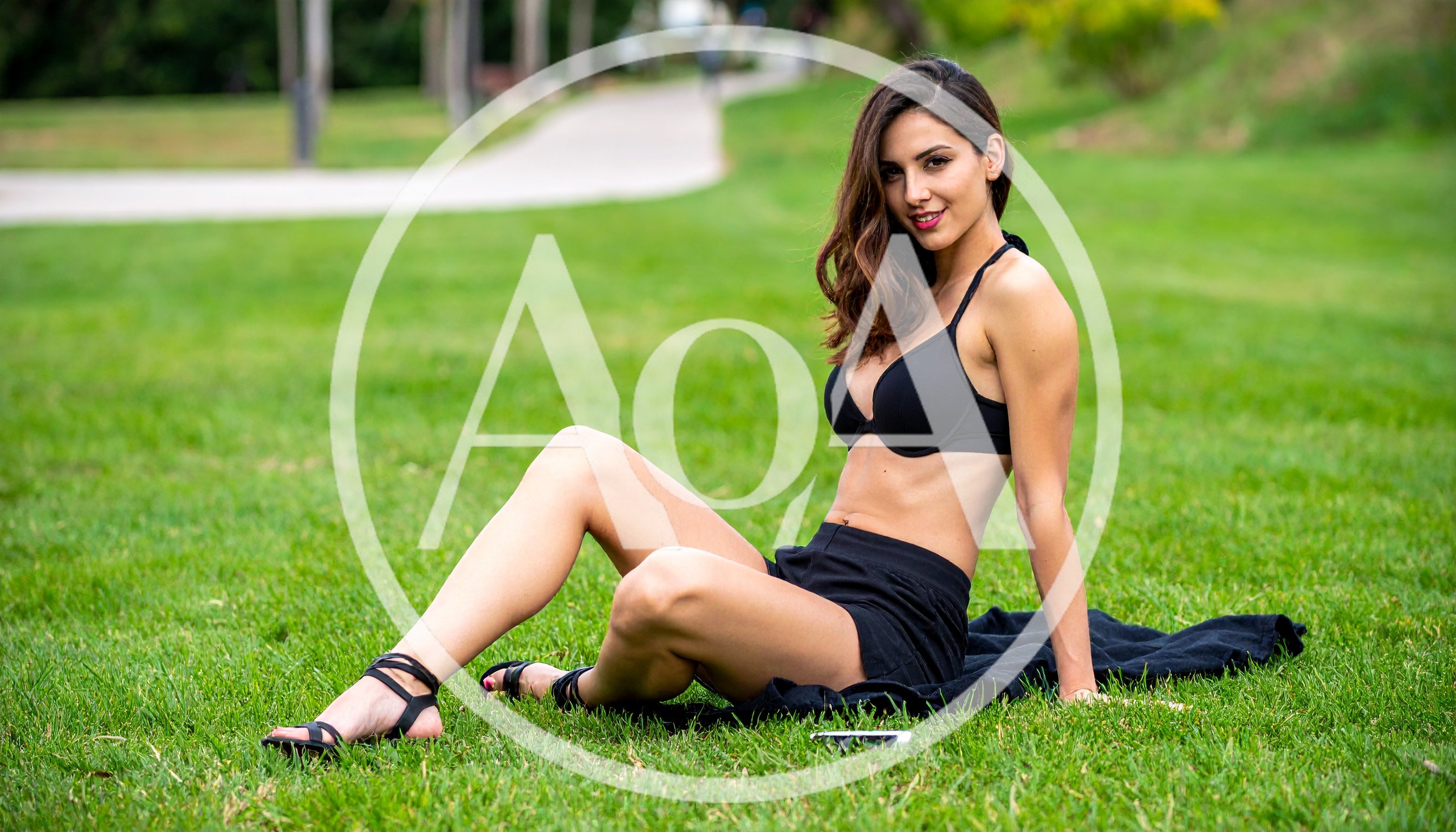 Young Woman Relaxing on Grass in a Park