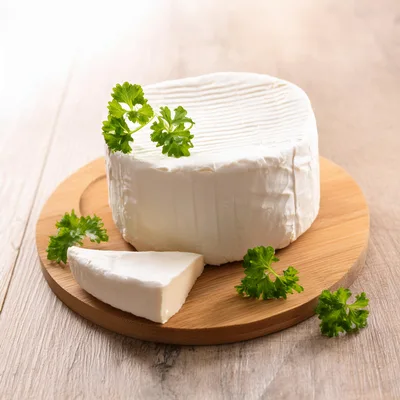 Round Brie Cheese Wheel With A Slice On Board