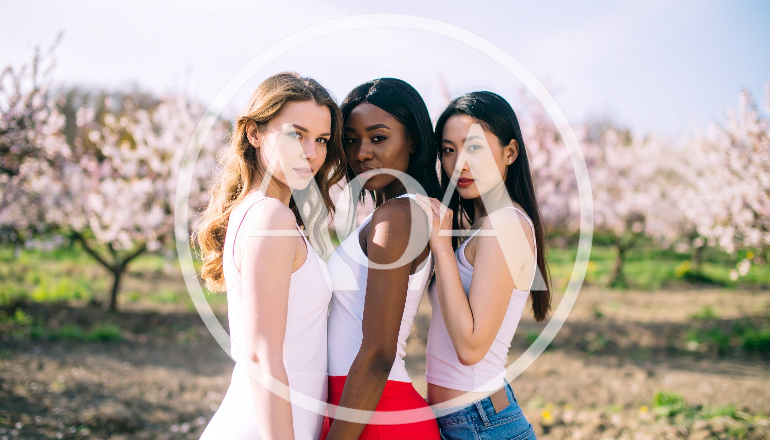 Three Diverse Women Posing Together In A Blooming Orchard