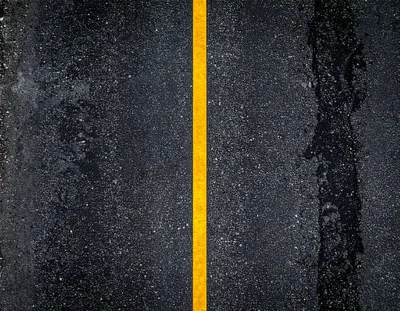 Aerial View Of A Wet Asphalt Road With Yellow Line