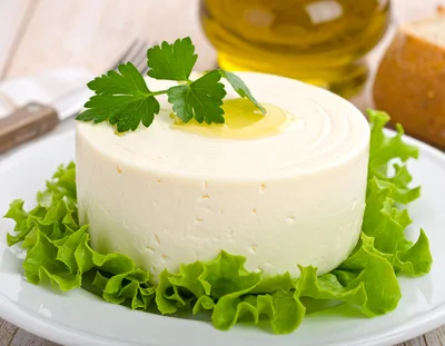 Fresh Round Cheese Wheel on Lettuce Bed