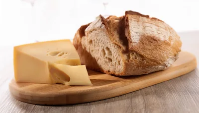 Wedge Of Swiss Cheese And Crusty Bread Loaf