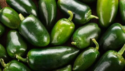 Fresh Green Jalapeno Peppers Arranged On Wooden Surface