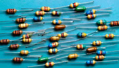 Assorted Electronic Resistors Scattered on Blue Background
