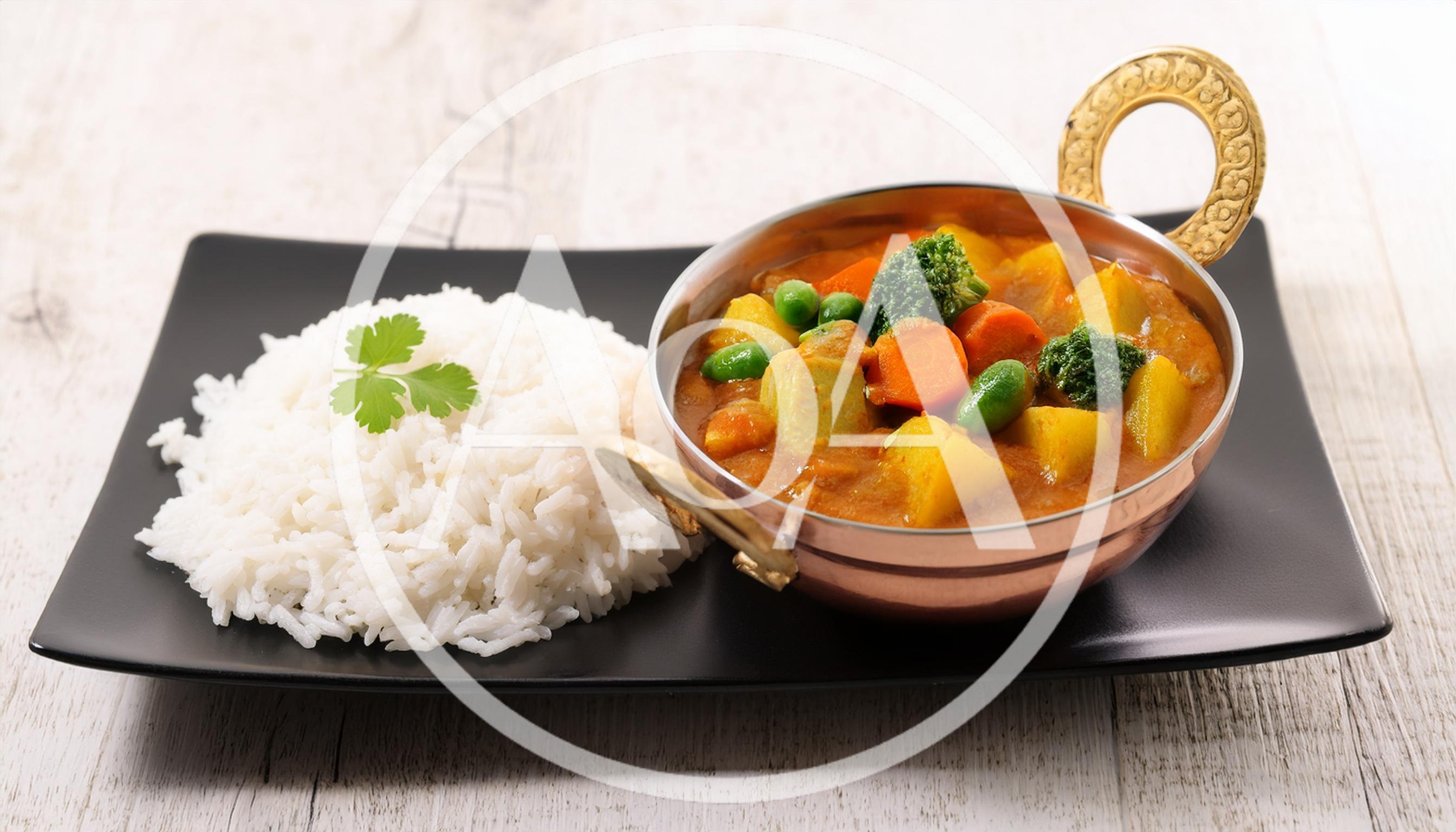Vegetable Curry With Steamed Rice On A Black Plate