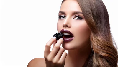Beautiful Woman Eating A Fresh Blackberry