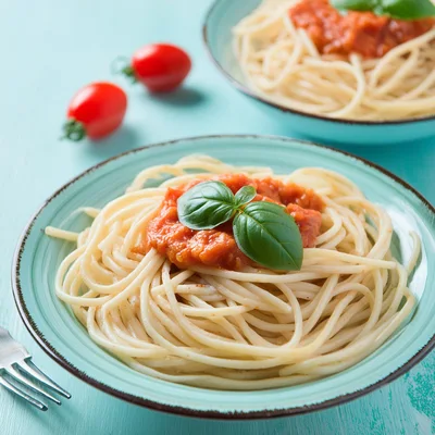 Two Plates Of Spaghetti With Tomato Sauce And Basil
