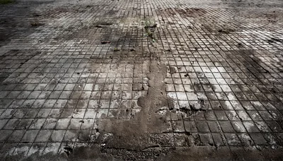 Worn And Cracked Concrete Tiled Ground Surface