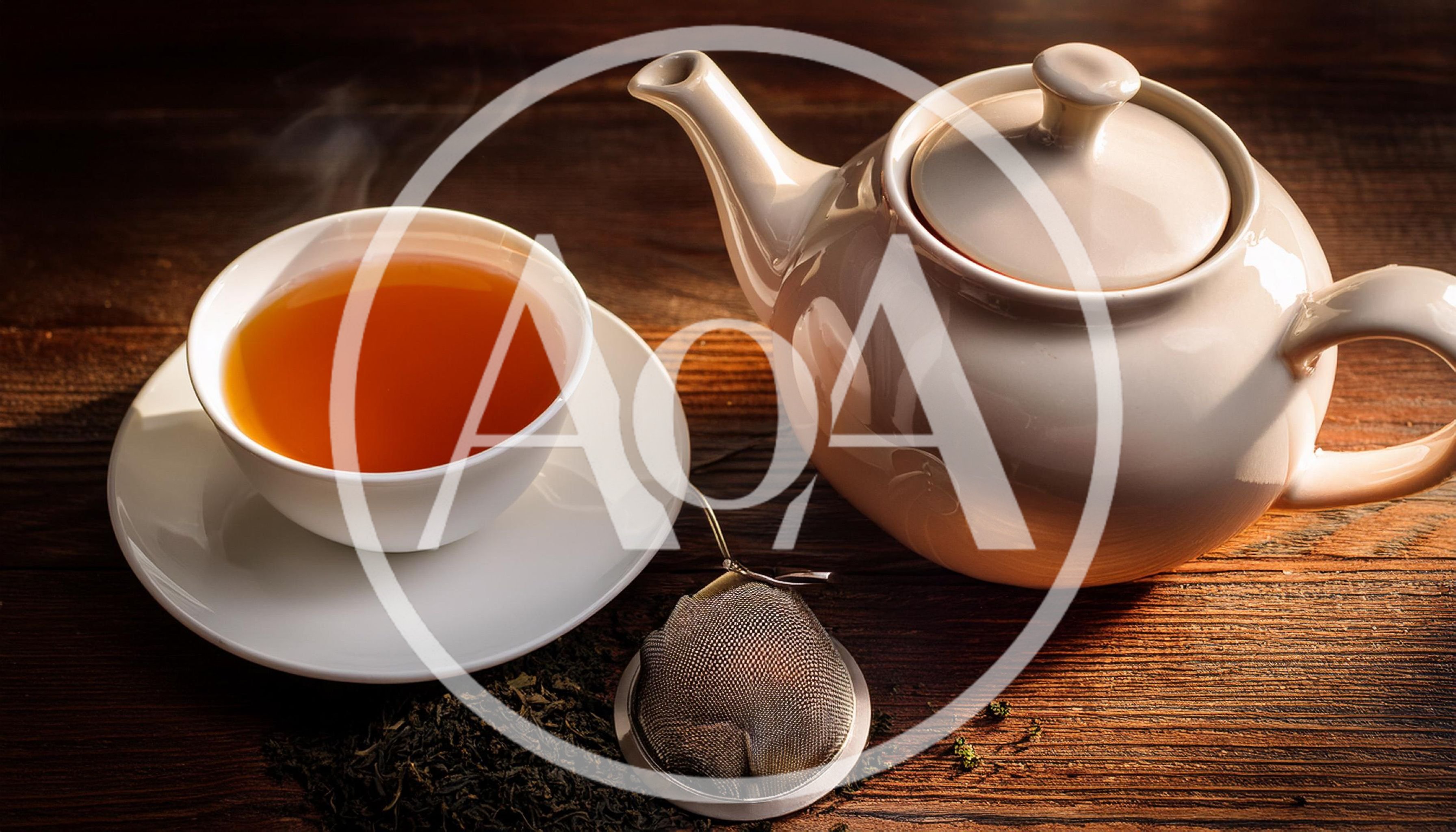 Steaming Cup Of Tea With Teapot And Infuser