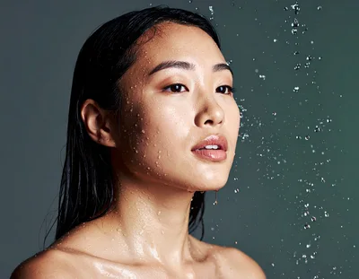 Young Asian Woman With Wet Skin Under Water Spray