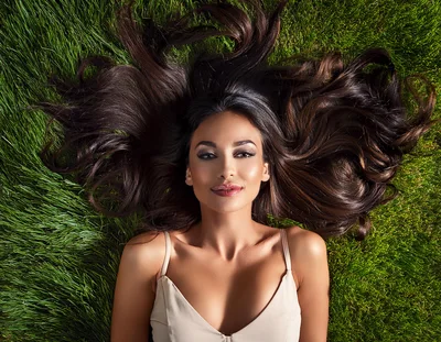 Beautiful Woman With Long Dark Hair Lying On Grass