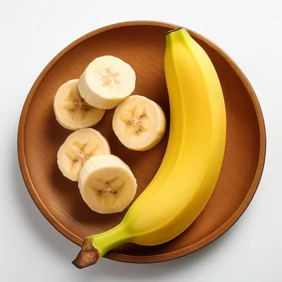 Whole Banana And Sliced Pieces On A Wooden Plate