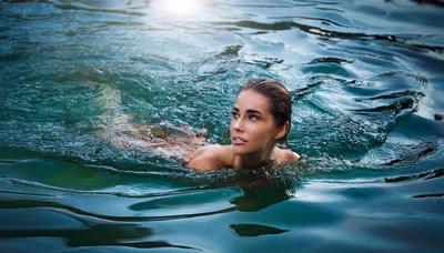 Young Woman Swimming In Clear Blue Water