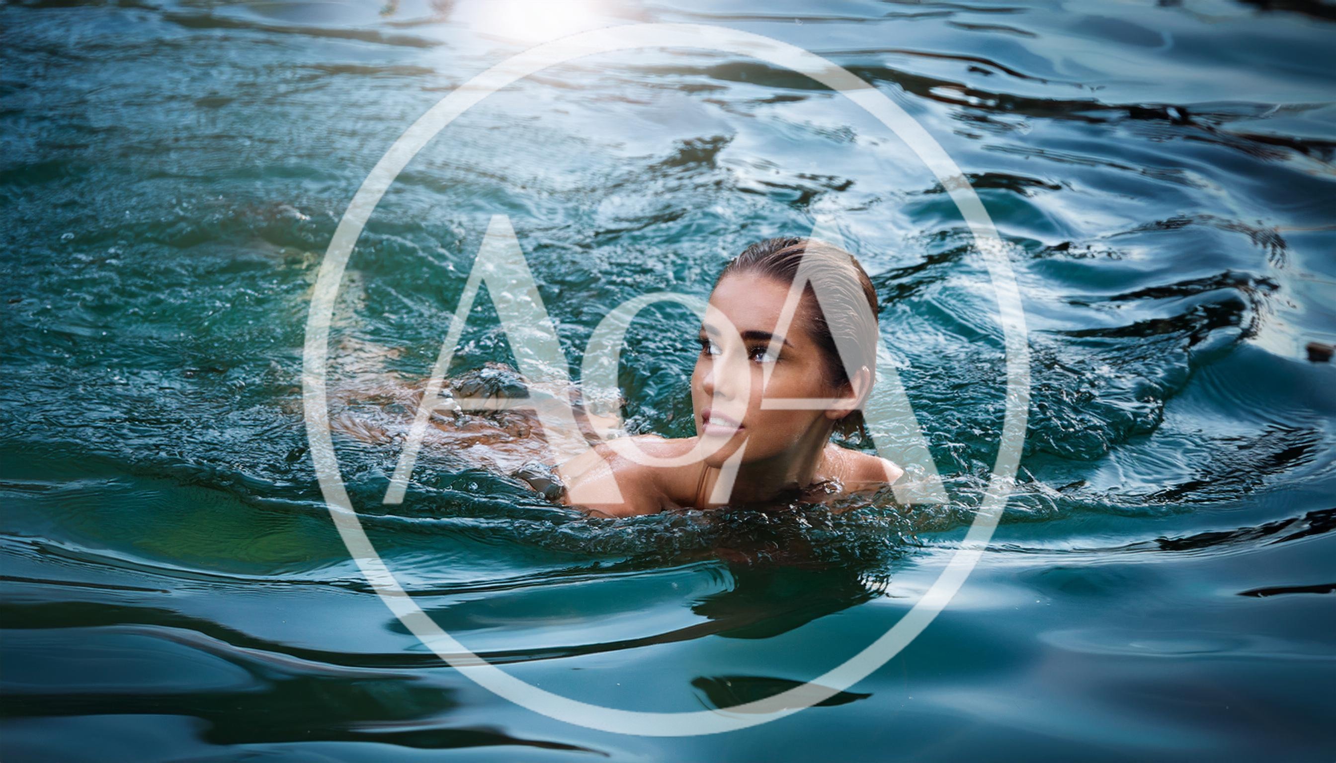 Young Woman Swimming In Clear Blue Water
