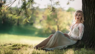 Elegant Blonde Woman Sitting Under A Tree