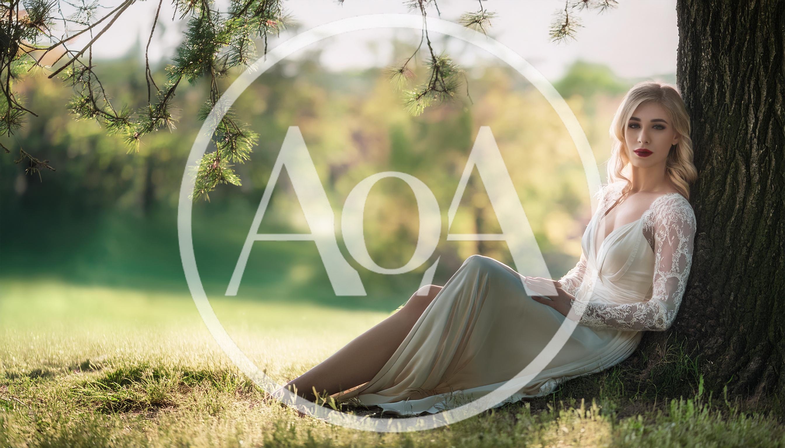 Elegant Blonde Woman Sitting Under A Tree