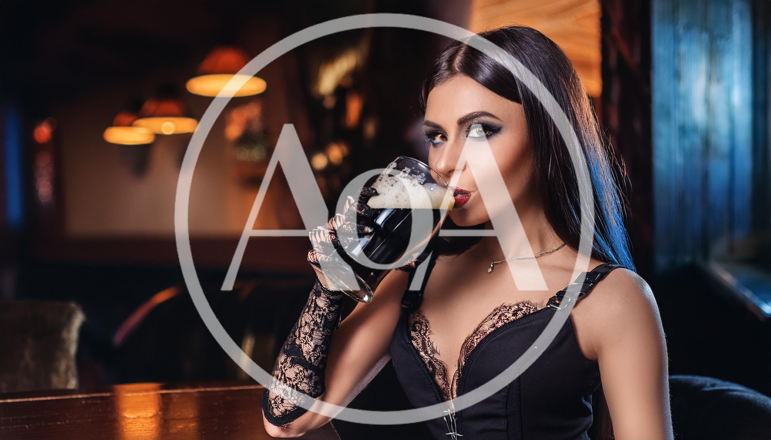 Elegant Woman Drinking Dark Beer In A Pub