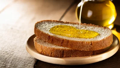 Olive Oil Pouring Over Fresh Slices Of Bread