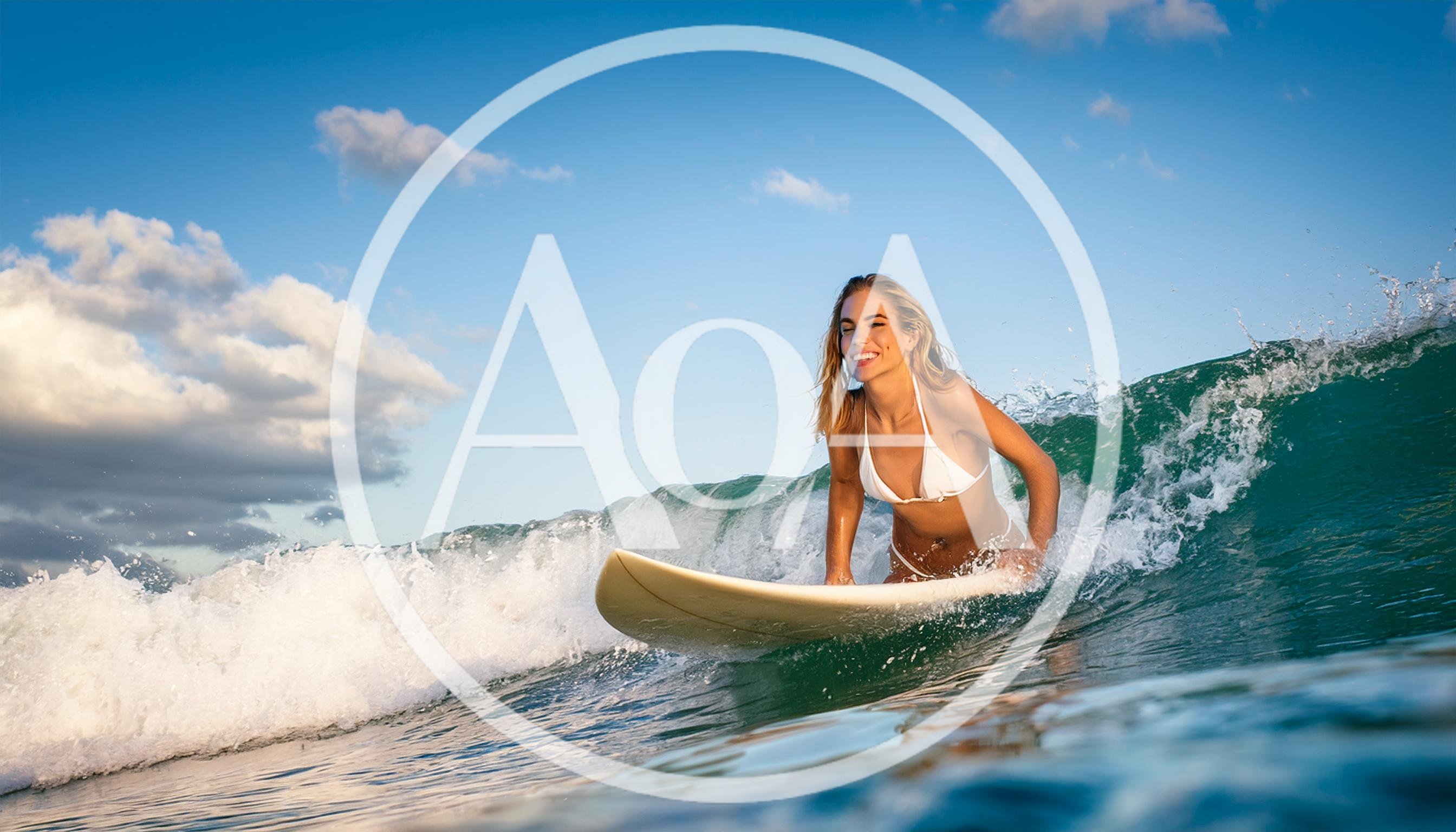 Young Woman Surfing On A Wave In The Ocean
