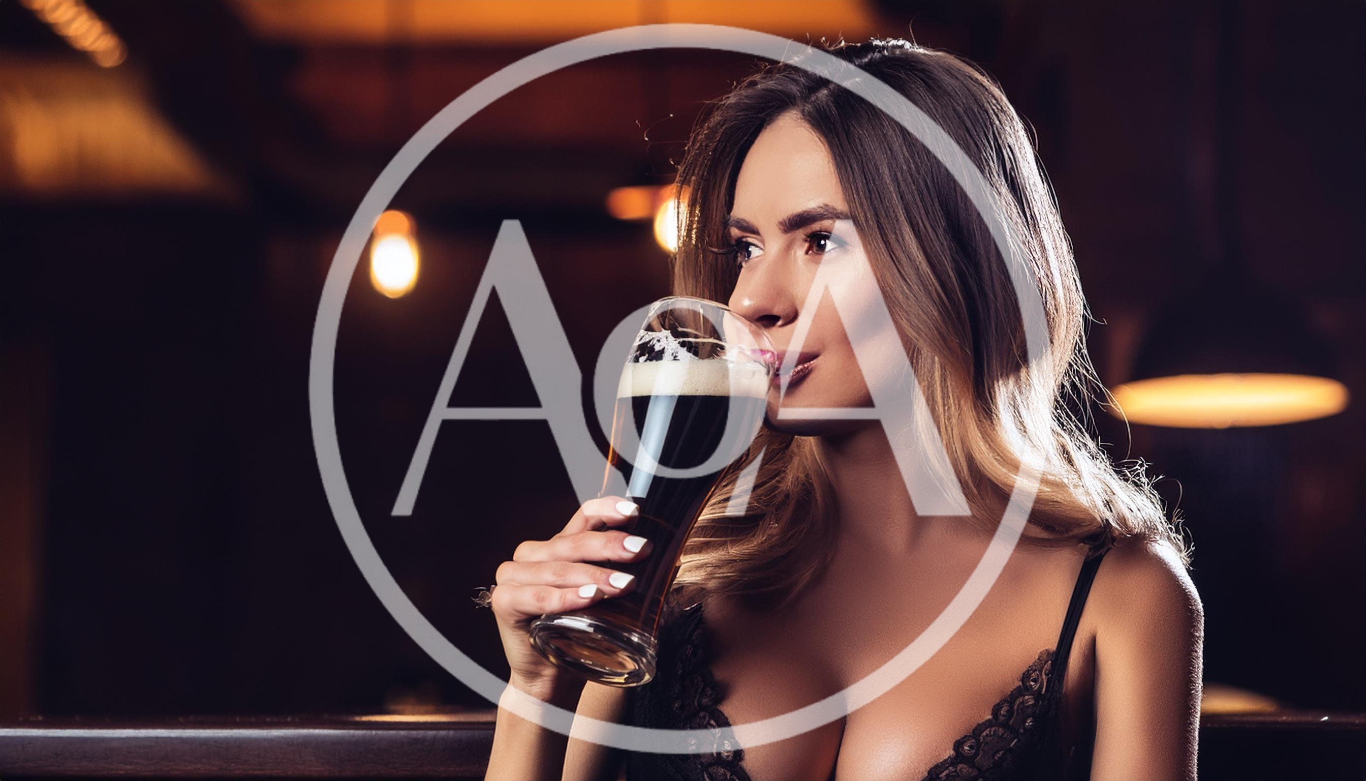Beautiful Woman Drinking Dark Beer In A Bar
